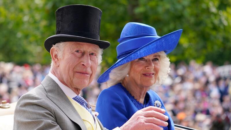 Exzentrische Hüte: Britinnen feiern in Ascot König Charles III. (l) und Königin Camilla kommen in einer Kutsche in Ascot an.