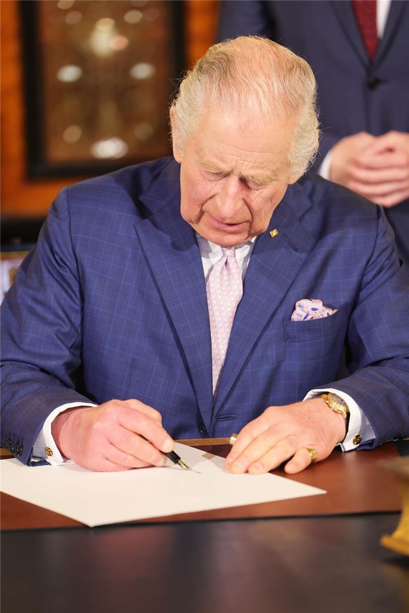 König Charles III. von Großbritannien trägt sich in das Goldene Buch im Hamburger Rathaus ein.