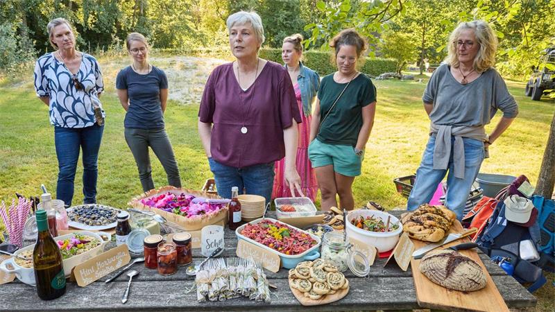 Brennnesseln statt Chia: Kräuterwanderung zur Heideblüte Kräuterfachwirtin Marion Putensen vor einem Buffet in Wilsede.