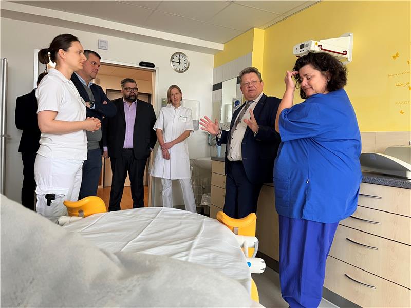 Mehrere Menschen besichtigen ein Zimmer in einem Krankenhaus.