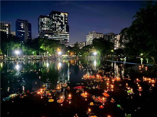 Krathongs schwimmen in einem See im Lumphini Park, einem der größten Parks Bangkoks.