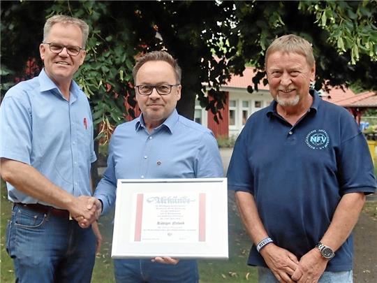 Kreisvorsitzender Rüdiger Nowak wird von Stefan Voth (li.) und Joachim Wojtke zur besonderen Auszeichnung beglückwünscht. Foto: Schacht