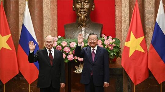 Kremlchef Wladimir Putin (l) und der vietnamesische Präsident To Lam posieren im Präsidentenpalast in Hanoi für die Fotografen.