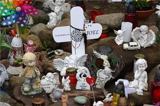 Kreuze, Figuren, Kerzen und Blumen stehen an der Stelle, wo der sechsjährige getötete Joel gefunden wurde. Der Prozess wegen Totschlags geht weiter.