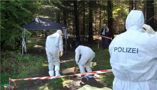 Kriminalbeamte untersuchen im Juni 2010 bei Heidenheim-Nietheim den Waldboden.
