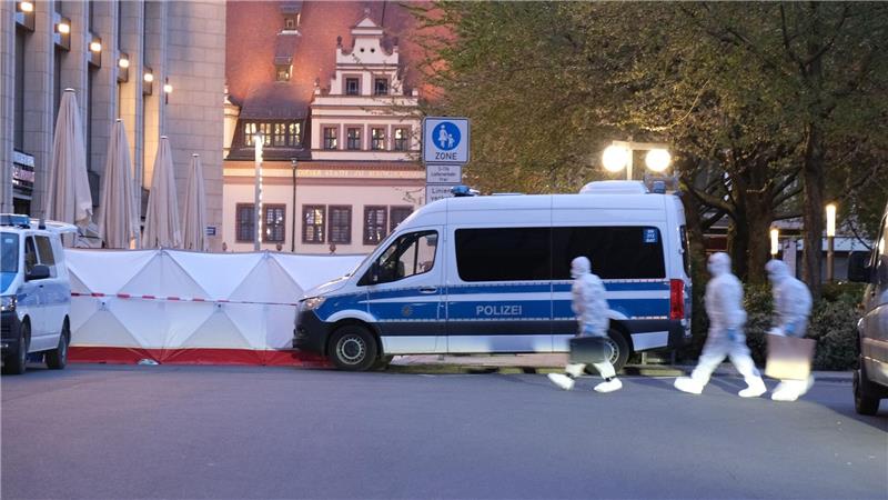 Kriminaltechniker gehen zum Tatfahrzeug. 