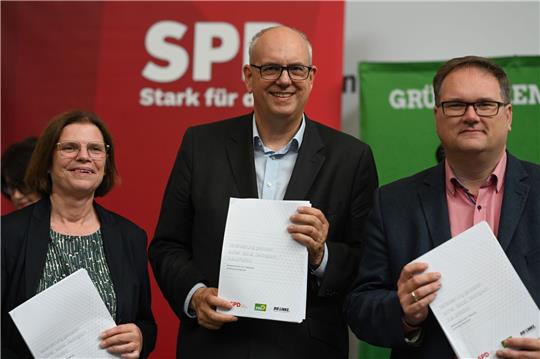 Kristina Vogt (Die Linke, l-r), Andreas Bovenschulte (SPD) und Björn Becker (Bündnis 90/Die Grünen) halten den unterschriebenen Koalitionsvertrag in der Hand.