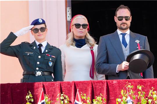 Kronprinzessin Mette-Marit (M), Kronprinz Haakon (r) und Prinzessin Ingrid Alexandra begrüßen den Kinderzug vom Schlossbalkon.