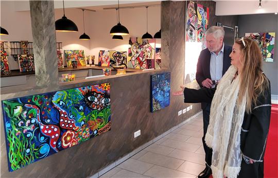 Künstlerin Rana Boustani führt Bad Harzburgs Bürgermeister Ralf Abrahms vor der Vernissage durch ihre Ausstellung.