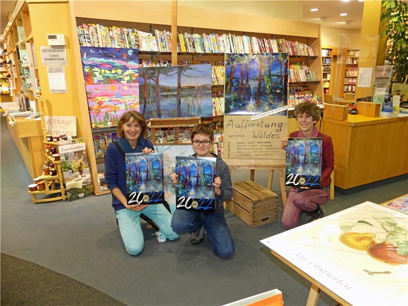 Künstlerin Tessa Funke, Schüler Merlin und Lions-Präsidentin Dagmar Daum (v. li.) präsentieren den neuen Kalender in der Grosse’schen Buchhandlung. Im Oktober geht es um die Sage „Der Rabe von Klaus thal“ (kleines Bild). Foto: Römhild
