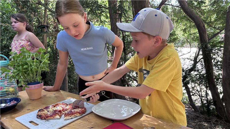 Kinder bereiten sich vor dem Jugendtreff eine Pizza zu.