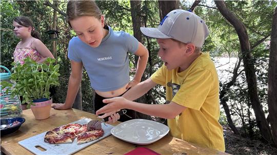 Kinder bereiten sich vor dem Jugendtreff eine Pizza zu.