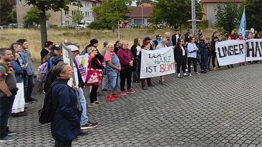 Eine Gruppe von Menschen steht mit Transparenten auf einem Platz.