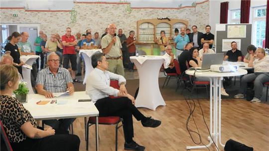 Kurt Hübner (in der Mitte mit Mikro) von der Windpark Lutter Verwaltungs GmbH spricht auf dem Informationsabend für die Grundstückseigentümer.