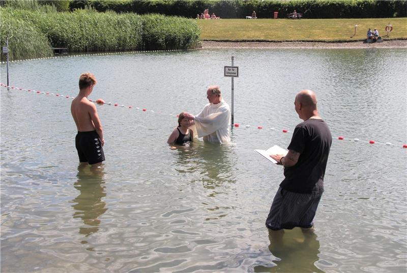 Am Rand des Teiches oder ganz hinein? Kurz vor dem Schwimmerbereich des beliebten Badeteichs in Schladen tauft Pfarrer Olaf Schäper ein junges Mädchen. Foto: Hohaus