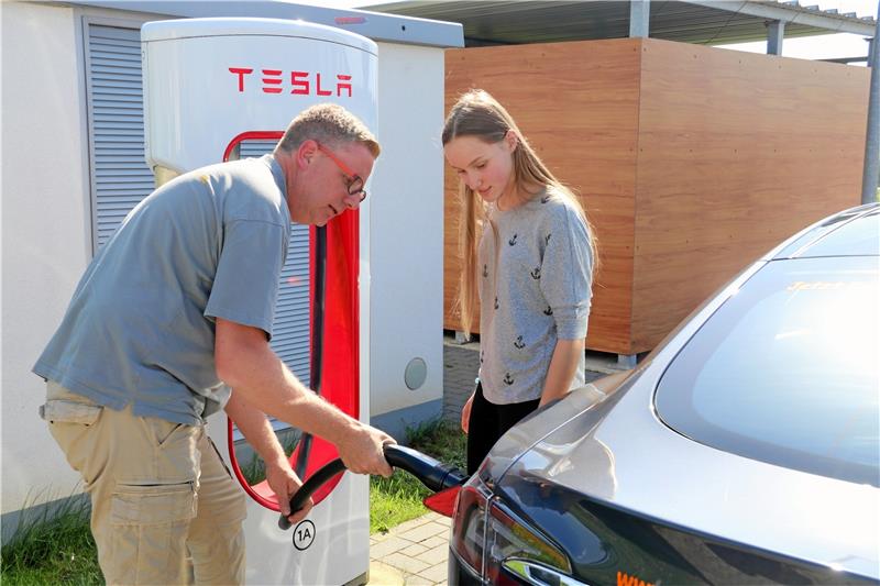 Ladestationen für den Tesla gibt es beispielsweise in Rhüden. Fahrlehrer Jens Mehmecke erklärt Anna Breiler, wie der Ladevorgang funktioniert.