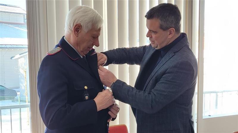 Landrat Alexander Saipa (r.) steckt Andreas Hoppstock das Bundesverdienstkreuz an.