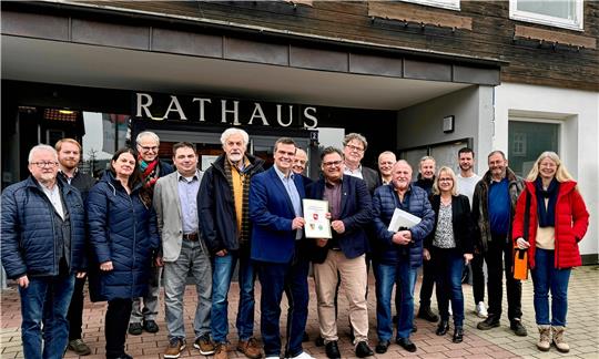 Landrat Dr. Alexander Saipa und Bürgermeister Wolfgang Langer (Mitte mit Urkunde, v.l.) unterzeichnen im Beisein von Verwaltungsmitarbeitern und Vertretern aus der Politik die Fortsetzung der Kommunalen Entwicklungspartnerschaft (KEP) bis 2025. Foto: Landkreis Goslar