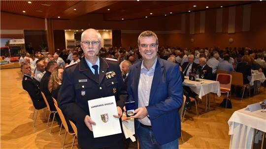 Landrat Dr. Alexander Saipa verleiht dem scheidenden Kreisbrandmeister Uwe Fricke (l.) eine Urkunde und die Ehrenmedaille des Landkreises für besondere Verdienste.