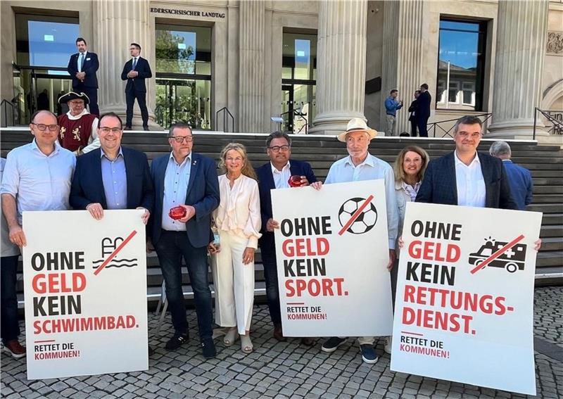 Mehrere Frauen und Männer stehen mit Plakaten vor dem Landtag in Hannover.