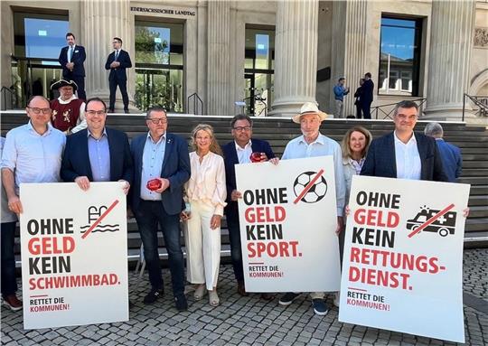 Mehrere Frauen und Männer stehen mit Plakaten vor dem Landtag in Hannover.