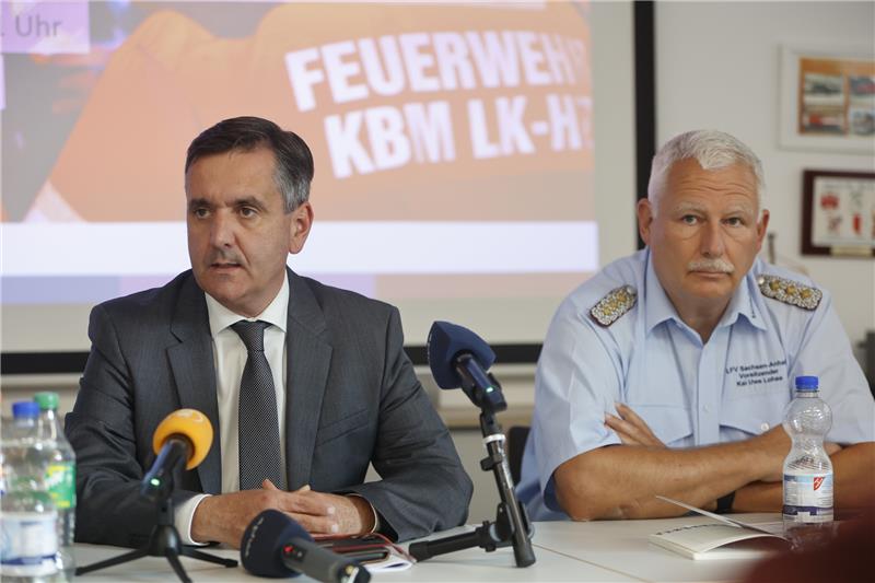 Landrat Thomas Balcerowski (links) sitzt neben Kreisbrandmeister Kai-Uwe Lohse während einer Pressekonferenz zum Abschluss des Waldbrandes am Brocken im Gerätehaus der Feuerwehr Schierke. Foto: Matthias Bein/DPA
