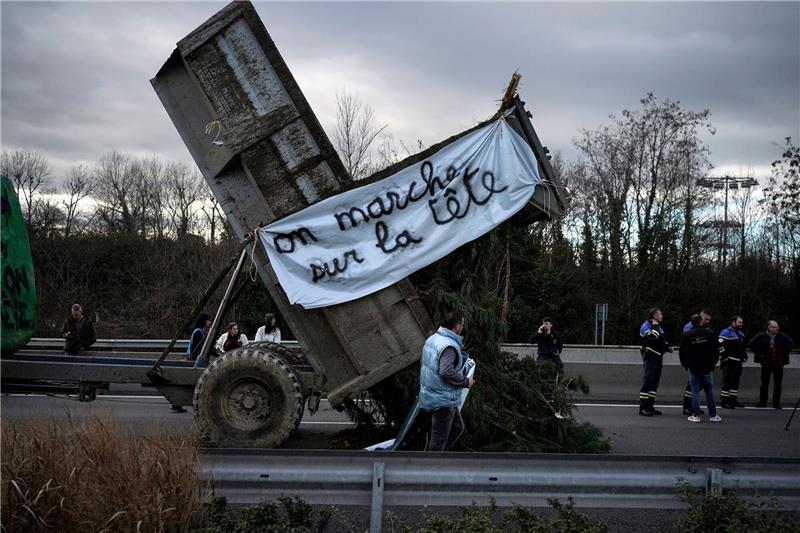 Landwirte kippen Zweige und Äste auf die Fahrbahn, während sie eine Autobahn in der Nähe von Lyon blockieren.