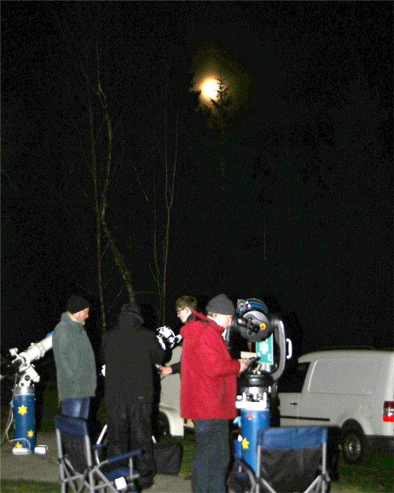 40 Besucher genießen die klare Vollmondnacht Langsam schiebt sich der Mond hinter den Fichten auf dem Freigelände der Sternwarte hervor, und die Besucher beobachten den Erdtrabanten per Teleskop, aber fotografieren ihn auch mit dem Handy. Foto: Jung