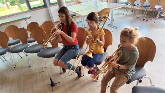 Die Ferienpasskinder Larissa, Johanna und Linus versuchen sich vor zwei Jahren an Blasinstrumenten.