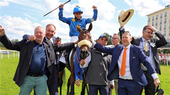 Lars-Wilhelm Baumgarten (2.v.r.) holt zusammen mit einigen Liberty-Racing-Mitgliedern den Hengst Palladium und seinen Reiter Thore Hammer-Hansen nach dem Derbysieg in Hamburg-Horn vom Geläuf ab. Foto: Sorge