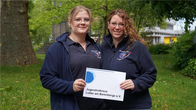 Zwei junge Frauen stehen nebeneinander. In der Hand ein Schild: Jugendrotkreuz Lutter.