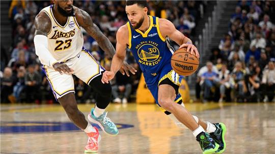 LeBron James (l) und die Los Angeles Lakers setzten sich bei den Golden State Warriors um Stephen Curry durch.