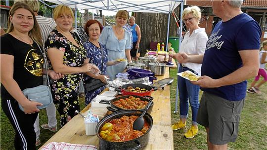 Leckeres Essen genießen die GZ-Gesprächspartnerinnen Natalia Kolesava (3. v. li.) und Marina Rohova (4. v. li.) im August vergangenen Jahres beim Sportfest in Lutter. Sie sind aus der Ukraine geflüchtet und leben zurzeit im Nordharz. Organisator ist der TSV Lutter, SV Neiletal und die Initiative „Lutter hilft“. Archivfoto: Biener