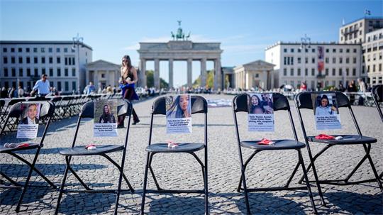 Leere Stühle mit Fotos erinnern am Brandenburger Tor an die Opfer des Hamas-Angriffs