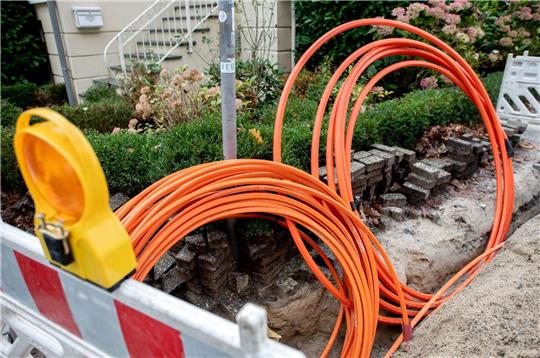 Leerrohre für neue Glasfaserkabel liegen auf einer Baustelle.