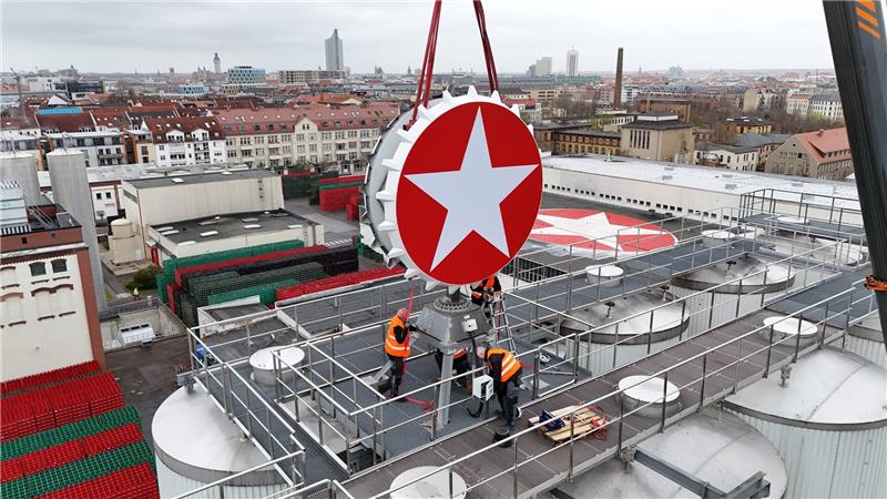 Leipzig: Der Sterni-Kronkorken ist wieder da – Kran hebt Kult-Leuchtreklame aufs Brauhaus