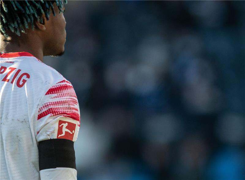 Leipzigs Mohamed Simakan spielt wie alle Spieler beider Teams mit einer schwarzen Binde am Arm.