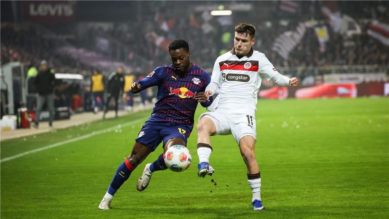 Leipzigs Ridle Baku (l) und St. Paulis Arkadiusz Pyrka kämpfen um den Ball.