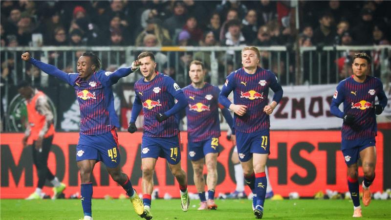 Leipzigs Yan Diomande (l,) jubelt nach seinem Treffer beim FC St. Pauli.