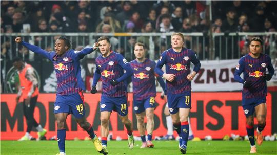 Leipzigs Yan Diomande (l,) jubelt nach seinem Treffer beim FC St. Pauli.