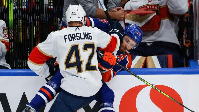 Leon Draisaitl von den Edmonton Oilers wird von Gustav Forsling von den Florida Panthers an die Bande gecheckt.