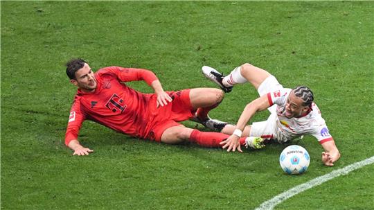 Leon Goretzka (l) und Leipzigs Xavi Simons kämpfen um den Ball.