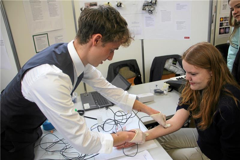 Leon Maximilian Koehler aus Braunschweig, Sieger der Kategorie Technik, befestigt Elektrodenpaare am Arm einer Probandin. Foto: Jenzora