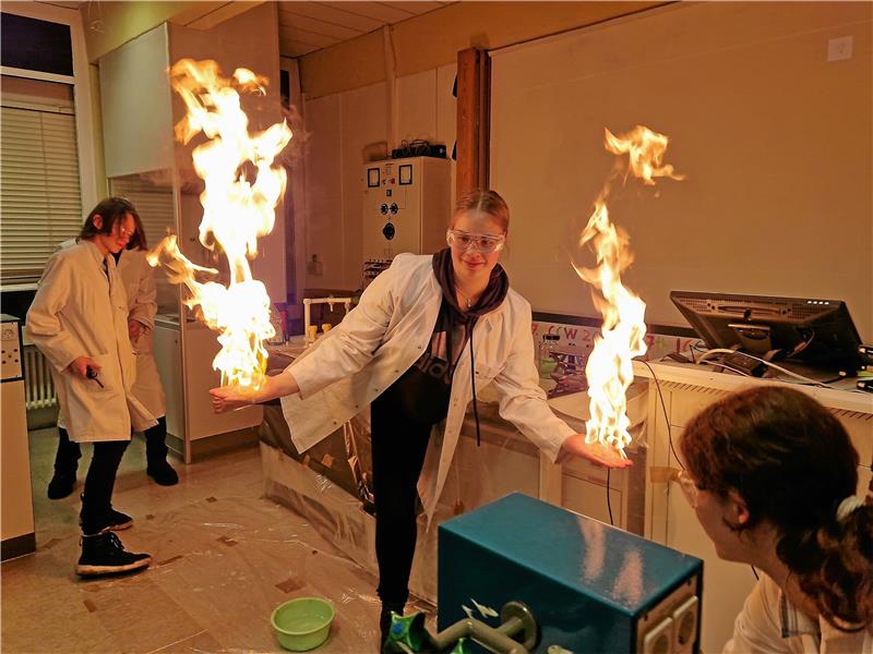 Chemie-Show in der RKS bietet feurigen Abschluss des Workshops Leonie steht bei der Chemie-Show in Flammen – aber keine Angst: Auf ihren Händen und Füßen hat sie einen Schaum aus Spülmittel, Alkohol und Gas. An ihrem Körper merkt sie daher das Feuer nicht. Foto: Knoke