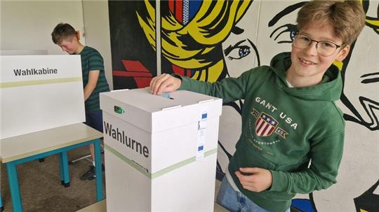 Leopold Röthele wirft seinen Stimmzettel in die Wahlurne. Im Hintergrund wählt Lio Rentzsch.