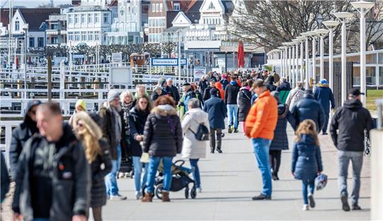 Leute sind am Samstagvormittag auf der Promenade von Travemünde unterwegs.