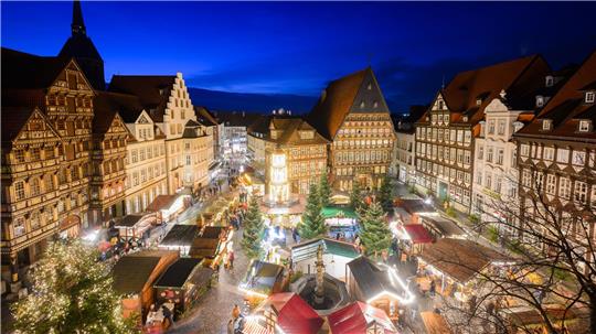 Lichter leuchten auf dem Hildesheimer Weihnachtsmarkt auf dem historischen Marktplatz mit dem Knochenhaueramtshaus.