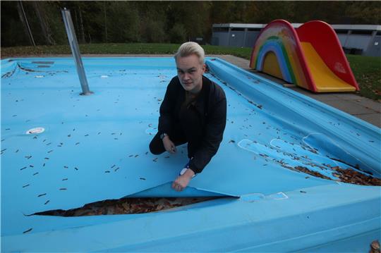Liebenburgs Schwimmmeister Lennart Dienelt präsentiert den neusten Riss in der Planschbeckenfolie. Die Schadstelle soll erst gar nicht mehr geflickt, vielmehr sollen beide Becken erneuert werden. Fotos: Gereke