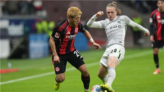 Lieferten sich eine umkämpfte Partie: Eintracht Frankfurt um Ritsu Doan (l) und der VfL Wolfsburg um Patrick Wimmer (r).