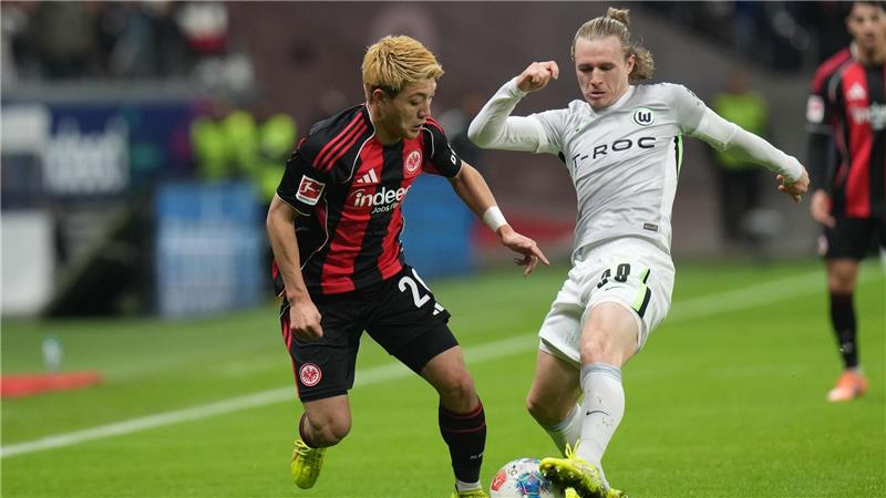 Lieferten sich eine umkämpfte Partie: Eintracht Frankfurt um Ritsu Doan (l) und der VfL Wolfsburg um Patrick Wimmer (r).